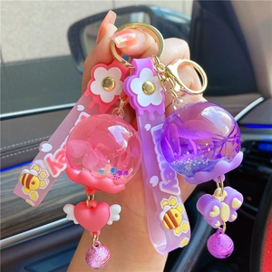 Close-up of glowing liquid keychains with dried flowers and glitter in a car interior