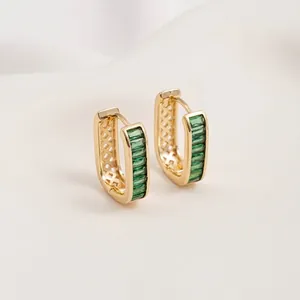 Close-up of 14K gold plated U-shaped earrings with emerald-cut green zircons