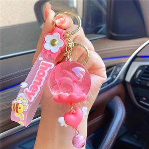 Detail of pink dried flower charm with silicone strap and golden metal clasp