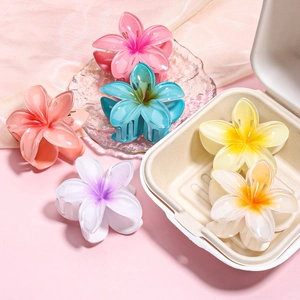 Detail view of colorful frangipani flower hair clips in various gradient pastel resin colors