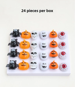 Detailed view of Halloween glowing rings set with pumpkin, skull, and bat designs