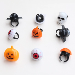 Detail view of adjustable Halloween plastic rings featuring pumpkin, skull, and bat designs