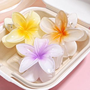 Macro detail of tropical frangipani flower hair claws in colorful resin with gradient petals