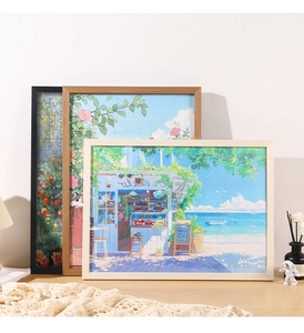 Three-frame display of solid wood jigsaw puzzle frames in black, white and natural wood