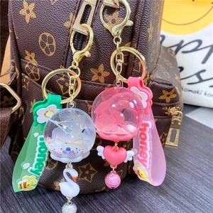Luminous floral whale keyring with liquid sand ball and swan charm on designer backpack
