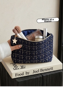 Detail of tweed makeup bag with star-shaped gold zipper and blue satin lining