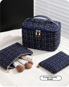 Three-piece dark blue tweed cosmetic bag set with golden star zippers on white fabric