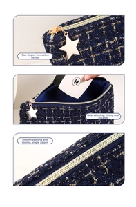 Detailed macro view of navy blue tweed fabric and a gold star-shaped zipper puller
