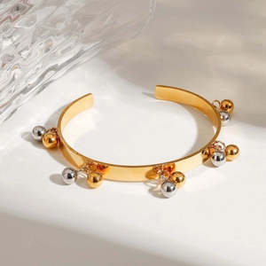 Polished two-tone 18K gold plated geometric open bangle with silver and gold sphere charms