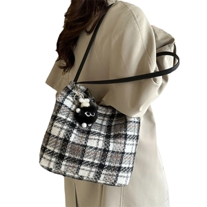 Chic black and white plaid canvas tote bag with a playful black plush monster keychain