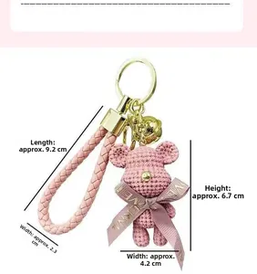 Detailed view of a pink knitted bear keychain with golden clasp and size annotations
