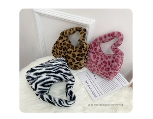 Detailed view of plush leopard and zebra print handbags on a soft faux fur background