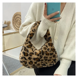 Detail of soft leopard print plush shoulder bag with crescent shape and furry texture