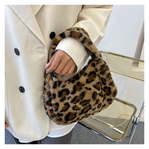 Detailed close-up of fluffy leopard print plush texture on stylish winter hobo bag