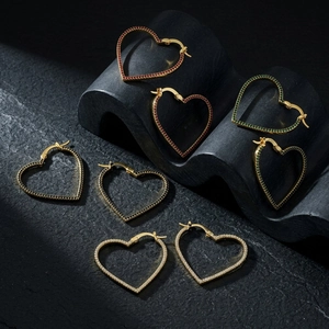 Detailed view of hollow heart earrings with inlaid zircons in red, green, black and white