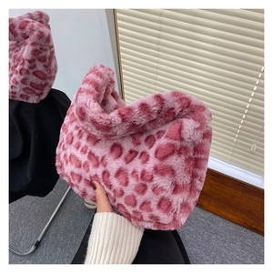 Detail of pink leopard print faux fur handbag with soft plush texture and integrated handle