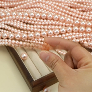Macro detail of high-luster champagne pink pearls showing smooth surface and drill holes