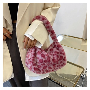 Close-up of pink leopard faux fur hobo bag styled with a white blazer and grey trousers