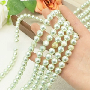 Detailed view of mint green round faux pearl beads for DIY jewelry making
