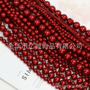 Macro view of glossy deep red imitation pearls in various sizes arranged in neat rows