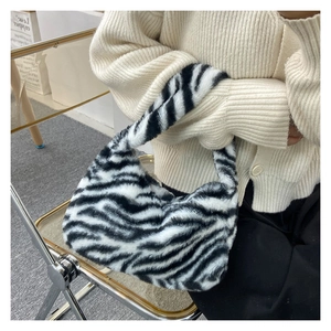 Detailed texture of black and white zebra print faux fur handbag on a fashion model