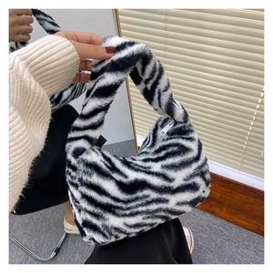 Detail of soft zebra print plush handbag with high-quality zipper closure and fluffy texture