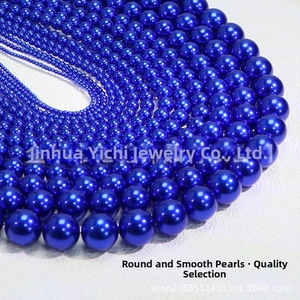 Macro detail of glossy royal blue faux pearls in various sizes for DIY jewelry making