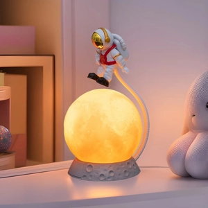 Astronaut moon lamp with levitating astronaut figurine on a textured crater base