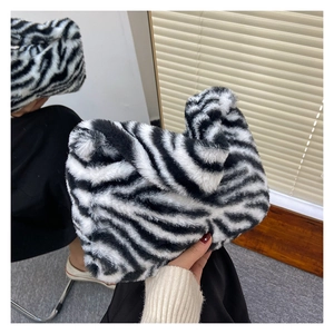 Detail of soft zebra print plush handbag with unique knotted handle for winter fashion