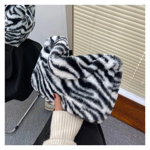 Detailed close-up of fluffy zebra print faux fur fabric on a trendy shoulder bag