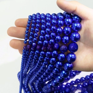 Close-up of high-gloss dark blue pearl beads in various sizes for DIY jewelry crafting