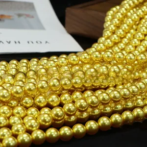 Macro detail of high-luster golden round craft beads for DIY jewelry and necklaces