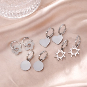 Set of four minimalist stainless steel heart and floral dangle earrings on silk fabric