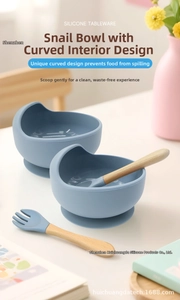 Detail of baby silicone snail suction bowls with wooden handle spoon and fork set
