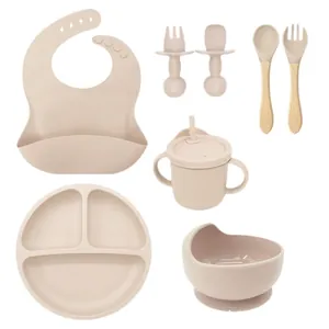 Beige 8-piece silicone baby feeding set with suction plate, bowl, bib, and learning cup