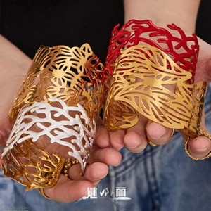 Dettaglio di ampi bracciali aperti con intricati motivi a foglia e corallo in oro e argento