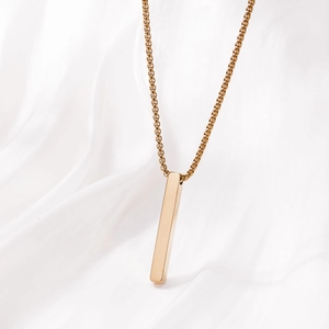 Minimalist gold stainless steel bar necklace with polished rectangular pendant on satin
