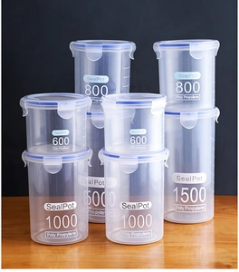 Detail of four transparent plastic food storage containers with blue lids and side locking buckles