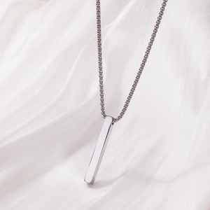 Polished stainless steel rectangular bar pendant necklace on elegant white silk background