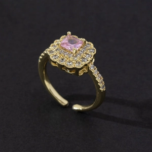 Detail of adjustable gold ring with a square pink zircon and sparkling halo setting