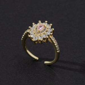 Macro view of adjustable gold ring featuring a pink pear-cut stone with zircon halo