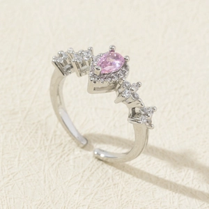 Macro detail of adjustable ring with pink pear-shaped stone and zircon halo setting