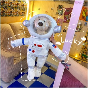 Close-up of a teddy bear inside a white PU astronaut suit with a transparent helmet