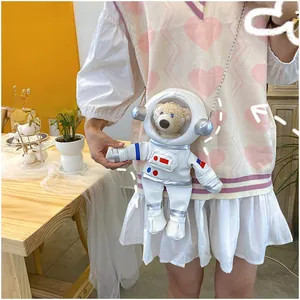 Detailed shot of an astronaut crossbody bag with a cute plush bear inside the helmet