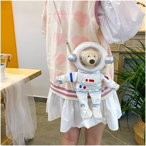 Detailed view of astronaut bear plush toy inside a white PU leather crossbody bag