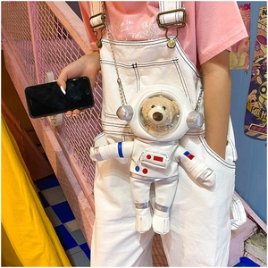 Detail of creative white PU astronaut bag with a cute plush bear inside the clear helmet