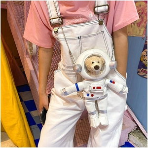 Detail of creative astronaut crossbody bag with a plush teddy bear inside a clear helmet