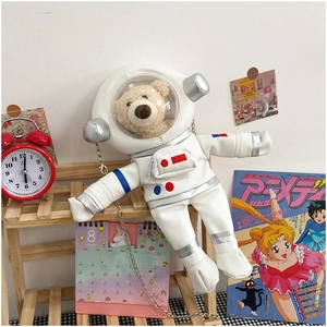 Detail of cute astronaut bear bag featuring a white patent leather finish and silver chain
