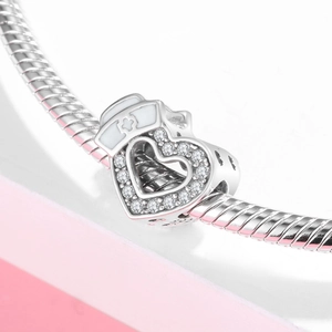 Macro shot of S925 silver heart nurse charm with zircon inlays and white enamel hat detail