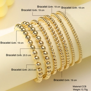 Set of seven gold beaded stretch bracelets in various sizes displayed on a jewelry stand